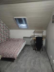 a small bedroom with a bed and a desk at Apartman M&D in Pančevo