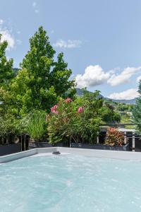 a swimming pool with flowers and trees in the background at Mountain View Suites in Tisens
