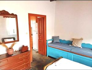 a bedroom with a blue bed and a mirror at Lefkiani House in Katapola +4 photos