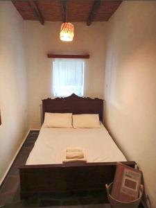 a bedroom with a bed in a room with a window at Lefkiani House in Katapola
