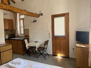 a kitchen with a table and a small kitchen with a television at Linos Old Barn in Theológos