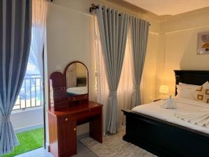 a bedroom with a mirror and a bed and a window at UrbanHive Naivasha Townhouse in Naivasha