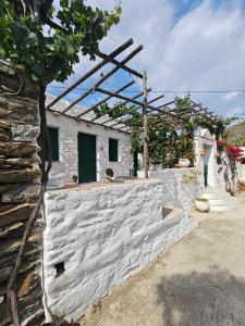 a white building with a wooden roof at Lefkiani House in Katapola