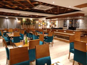 a restaurant with wooden tables and blue chairs at Yelchiko in Varanasi