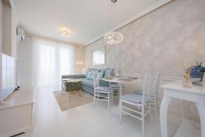 a living room with a couch and a table and chairs at Second Home Luxury Apartman in Siófok