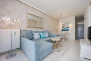 a living room with a blue couch and a table at Second Home Luxury Apartman in Siófok