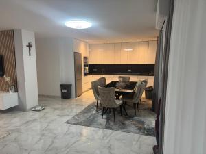 a dining room with a table and chairs and a kitchen at Apartman Provo in Široki Brijeg