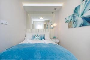 a bedroom with a large bed with blue sheets at Second Home Luxury Apartman in Siófok +39 photos