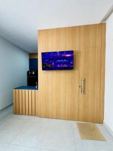 a room with a wooden wall with a tv on it at Flat completo em condomínio in Camocim