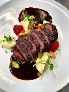 a piece of meat on a white plate with sauce at Hotel-Restaurant Peifer in Brodenbach +24 photos