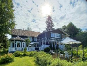 a large blue house with a white porch at Villa Gargano in Pieksämäki