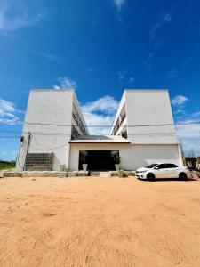 a white car parked in front of a building at Flat completo em condomínio in Camocim