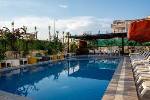 a swimming pool with white chairs and a building at Velaris Boutıque Hotel in Belek