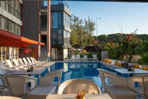 a hotel patio with tables and chairs and a pool at Velaris Boutıque Hotel in Belek