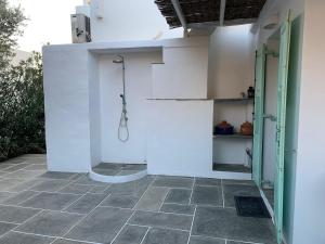 a bathroom with a shower in a white wall at Villa Thalassa - Vathy in Sifnos +19 photos
