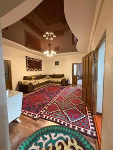 a living room with a large rug on the floor at Son kol Keng suu guesthouse in Keng-Suu