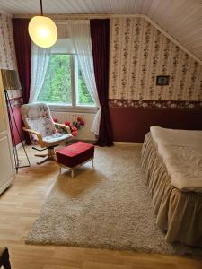 a bedroom with a bed and a chair and a window at Villa Gargano in Pieksämäki