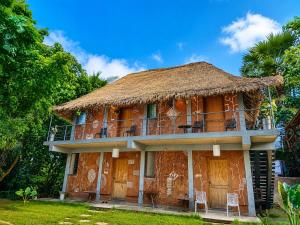 an old house with a thatched roof at Avora Auroville in Auroville