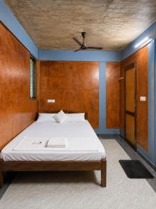 a bedroom with a large bed with a wooden headboard at Avora Auroville in Auroville