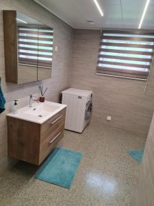 ein Badezimmer mit Waschbecken und kleinem Kühlschrank in der Unterkunft Sand in Sand