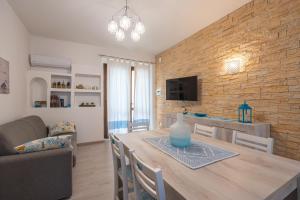 a dining room and living room with a table and a couch at Appartamento La Pelosa in Stintino