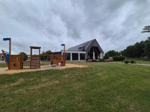 a house with a playground in front of a field at Riverside house Duna in Rajka