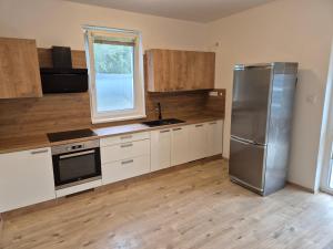 a kitchen with a stainless steel refrigerator and a window at Riverside house Duna in Rajka