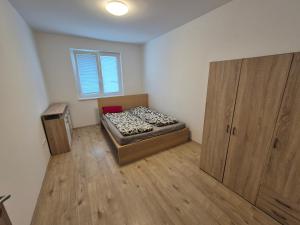 a small bedroom with a bed and a window at Riverside house Duna in Rajka