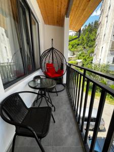 a balcony with two chairs and a swing at OR-Ni in Borjomi