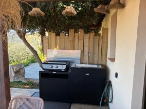 a barbecue grill on a patio with a fence at La bergerie de Cupabia in Serra-di-Ferro