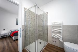 a glass shower in a bathroom with a bed at Il Nido Dei Ribelli in Mergo
