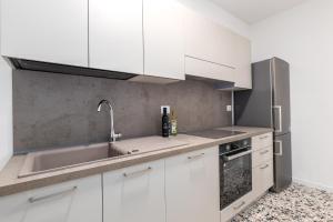 a kitchen with white cabinets and a sink at Il Nido Dei Ribelli in Mergo