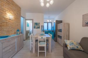 a kitchen and living room with a table and chairs at Appartamento La Pelosa in Stintino