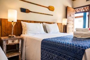 a bedroom with two beds with a blue and white comforter at Pousada Alto da Vila Noronha by Alto da Ilha in Fernando de Noronha
