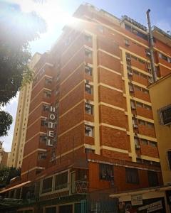 a tall building with the sun shining on it at Hotel Harmony in Caracas