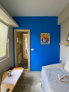 a blue room with a bed and a table at Vila Bilja in Požega