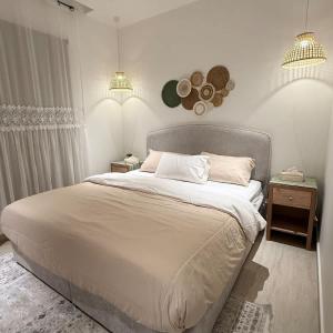 a bedroom with a large bed and two night stands at Bali island Home2 in Al Khobar