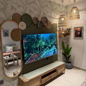 a television in a living room with a mirror at Bali island Home2 in Al Khobar