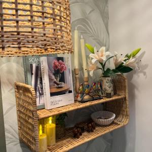 a wicker shelf with books and flowers and candles at Bali island Home2 in Al Khobar +34 photos