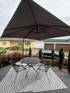 a table and chairs under an umbrella on a patio at Villa Basilika - Ferienwohnung Prüm in Prüm