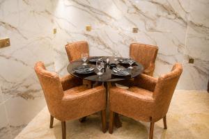 a dining room table with two chairs and a table with glasses at Diamond Motel in Baghdād
