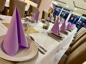 a long table with purple napkins on top of it at Hotel Kutina in Kutina