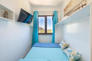 a small bedroom with a bed and a window at Appartamento La Pelosa in Stintino +158 photos