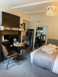 a bedroom with a bed and a table and a mirror at Cobweb Cottage in Patrington