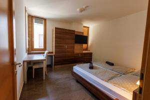 a bedroom with two beds and a desk and a table at Jacht Apartmanok in Balatonfüred