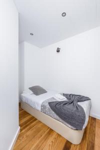 a white bedroom with a bed in a room at A Lodge in Blue in Aveiro