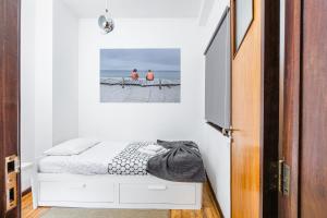 a small bedroom with a bed and a picture on the wall at A Lodge in Blue in Aveiro +17 photos