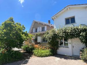 a large white house with a white garage at Maison d'Hôtes L'Escale Du Loup Blanc in Maringes