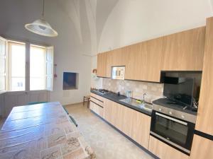 a large kitchen with wooden cabinets and a table at Salento mare in Casalabate