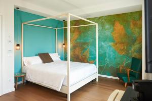a bedroom with a white bed and a colorful wall at Hotel B&B il Mosaico in Sirmione +72 photos